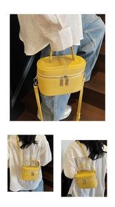 Détail du sac seau en cuir jaune vif avec motif litchi et doubles fermetures éclair