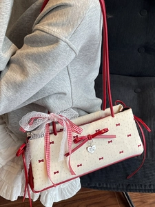 Borsa a spalla color crema con stampe di fiocchi rossi e un grande fiocco in pizzo vichy
