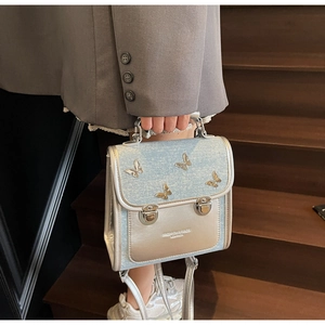 Close-up of light blue glitter backpack with metal butterfly buckles on wooden steps