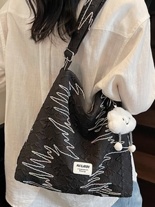Large black textured canvas tote bag with colorful embroidery and plush cloud charm
