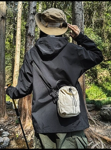 Close-up of beige drawstring bucket bag used by hiker in outdoor forest setting