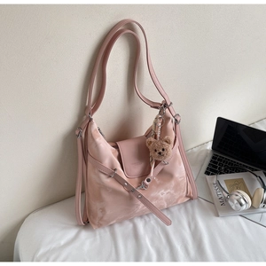 Rosa Hobo Tasche mit Marmortextur und braunem Teddybär Anhänger im Detail präsentiert