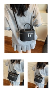 Détail du sac carré en cuir noir grainé avec double fermeture éclair et bandoulière