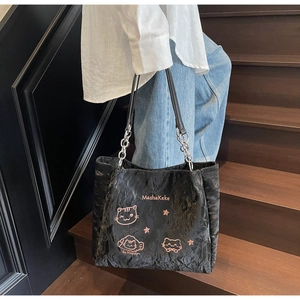 Detail der schwarzen Plissee-Tasche mit rosa Katzenstickerei und Kettenschultergurt