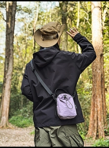 Outdoor lifestyle view of a lavender nylon bucket bag with adjustable drawstring strap