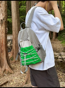 Close-up of lightweight hiking backpack with grey fabric and bright green cord pocket detail