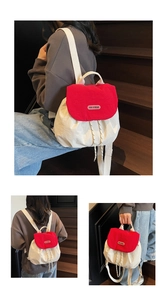 Dettaglio dello zaino in nylon con coulisse, tessuto crema e patta rossa a contrasto