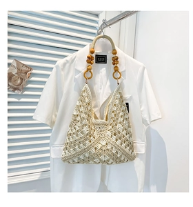 Detailed close-up of woven tote bag featuring natural wood beads and ivory knitted texture
