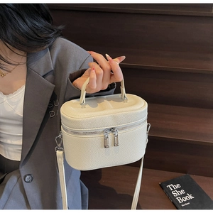 Détail du sac à main blanc en cuir grainé avec fermetures éclair métalliques argentées
