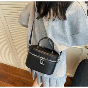 Détail du sac bandoulière boîte noir à motif litchi avec zips argentés et poignée haute