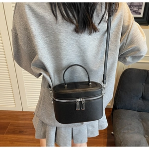 Sac seau en cuir grainé litchi porté en bandoulière vu de dos sur un mannequin