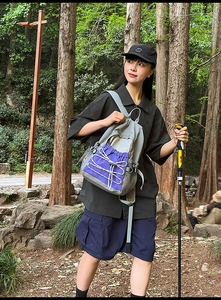 Close-up of lightweight hiking backpack featuring purple contrast design and bungee system