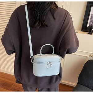 Détail d'un sac à main bleu clair en cuir grainé avec fermeture éclair argentée double