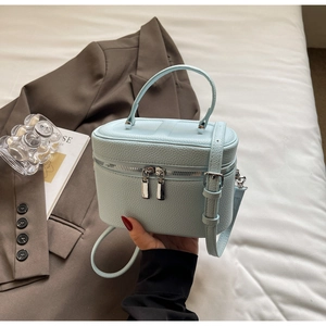 Sac cosmétique en cuir bleu clair avec motif litchi, double fermeture et détails argentés