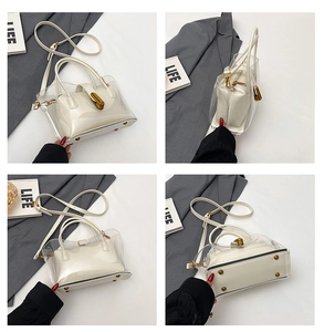 Detail view of transparent PVC tote bag with white leather pouch and metal turn lock