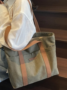 Large capacity canvas tote bag with brown straps and side pockets for casual daily commute
