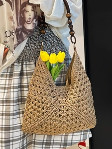 Large woven straw tote bag with hollow diamond pattern and dark wooden bead shoulder strap