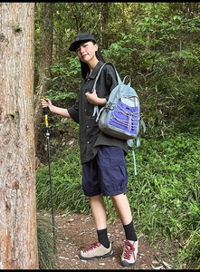 Outdoor waterproof backpack detail showing purple drawstring pocket and hiking gear