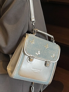 Silver mirror leather butterfly shoulder bag with glitter details shown on a model