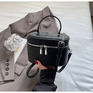 Détail du sac vanity noir en cuir grainé avec fermetures éclair argentées chics