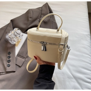 Détail du mini sac boîte blanc crème en cuir grainé avec fermetures éclair argentées