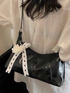 Chic black crescent underarm bag in cracked patent leather with pearl heart and ribbon