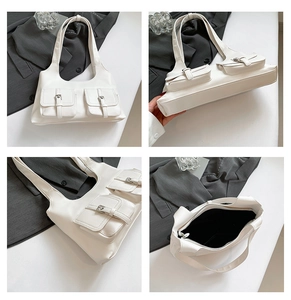 Detail view showing dual buckle pockets and interior of white minimalist shoulder bag
