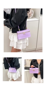 Detail view of purple crocodile pattern leather mini handbag with gold hardware