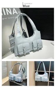Detail of light blue hobo bag showing twin utility pockets and silver metal buckles