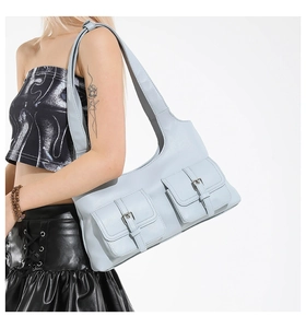 Detail of light blue shoulder bag featuring dual front pockets and silver metal buckles