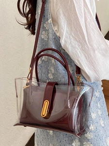 Modern transparent PVC jelly tote bag with a deep burgundy inner pouch and gold hardware