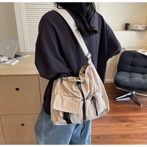 Detailed back view of a beige waterproof nylon shoulder bag with adjustable strap