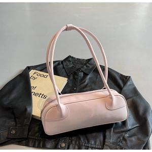 Detailed top view of a pink baguette shoulder bag on black leather background