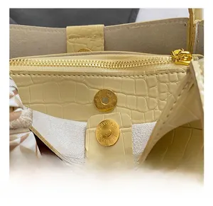 Vue macro du fermoir magnétique doré et du cuir gaufré crocodile du sac jaune