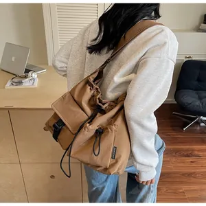 Detailed side view of khaki nylon crossbody bag with drawstring pockets on a model