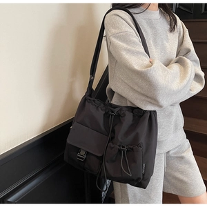 Detail shot of large waterproof nylon shoulder bag with drawstring and side buckle pocket