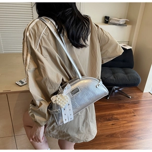Sac argenté avec nœud en dentelle, breloque cœur en perles et texture plissée