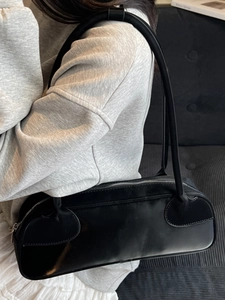 Minimalist black Boston underarm bag in matte leather with a sleek shoulder strap design