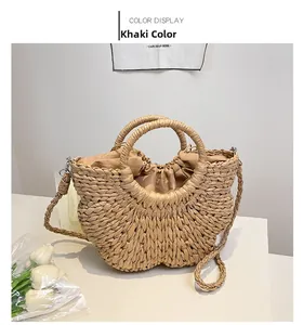 Détail du sac demi-lune en paille kaki avec poignées tressées et pochette intérieure