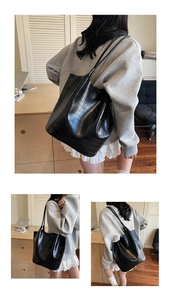 Detail of black crocodile texture tote bag with long shoulder straps for daily commuting
