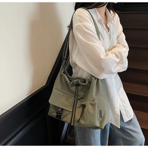 Detailed view of olive green waterproof nylon drawstring tote bag worn by a model