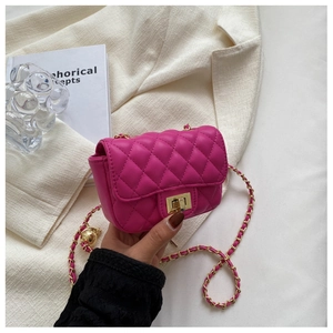 Close-up of fuchsia quilted handbag with gold twist lock and woven chain strap