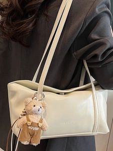 Borsa a tracolla quadrata beige con ciondolo a forma di orsetto e logo CLEAROK