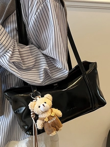 Borsa a tracolla nera lucida minimalista con ciondolo a forma di orsetto peluche