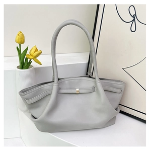 Detail view of light grey tote bag with soft leather texture and stylish metal buckle strap
