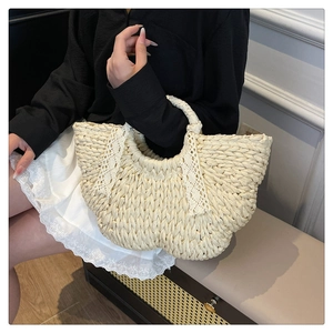 Détail d'un sac en paille crème avec un nœud en dentelle blanche et texture artisanale