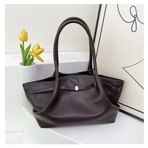 Detailed view of dark brown tote bag with decorative gold buckle and side pleats