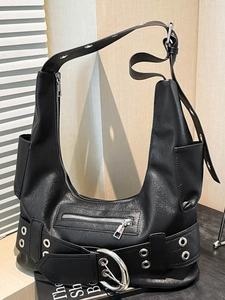 Vintage black leather hobo bag with large silver buckles and metal eyelets on books