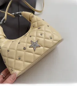 Detailed close-up of cream quilted underarm bag with sparkling star rhinestones and studs
