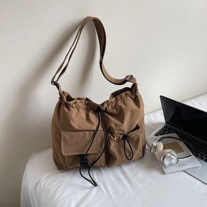 Detail view of large nylon shoulder bag with adjustable strap and drawstring pockets